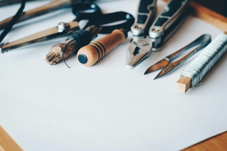 A selection of artisan tools and handmade crafts displayed on a white desk, perfect for creative projects.